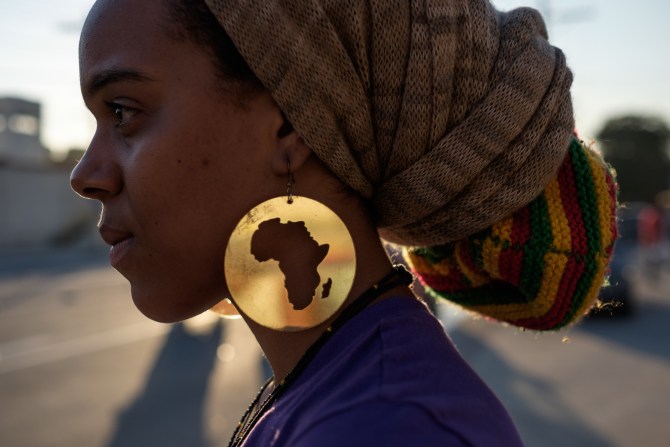 A protester wearing earrings with the map
