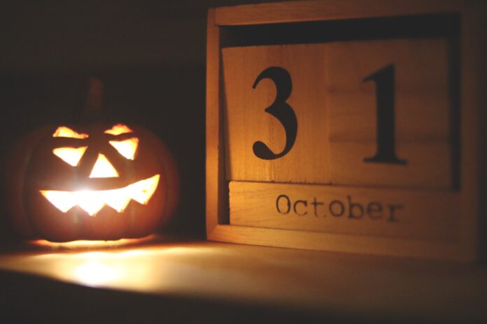 a Jack-O-Lantern is posed next to a calendar displaying the Halloween date.