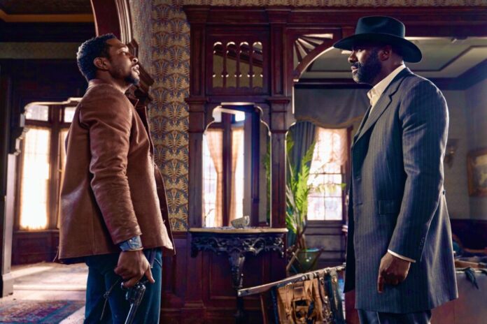 Jonathan Majors and Idris Elba in a scene from the movie 'The Harder They Fall'