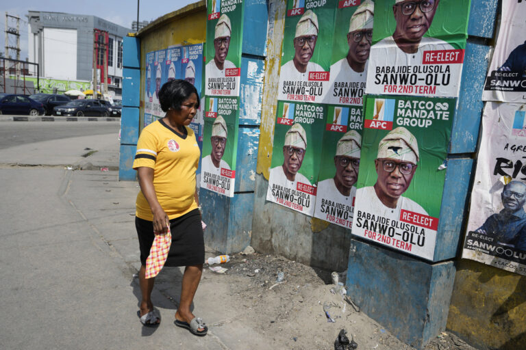 A woman walks past election campaign posters